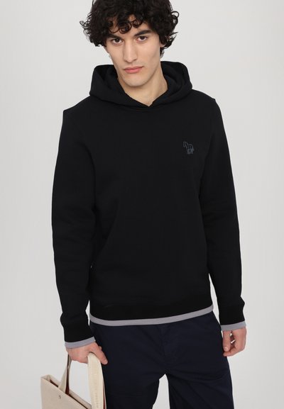 Black hoodie featuring a soft fabric, kangaroo pocket, and ribbed cuffs. Notable grey trim at the hem and a simple embroidered logo.