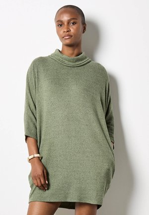 Abito in maglia oversized color verde oliva, con collo a cowl, maniche corte, tessuto testurizzato e tasche laterali.