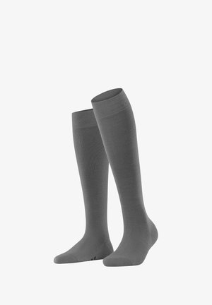 Dwie szare skarpetki sięgające do kolan są wyeksponowane obok siebie, ukazując swoją gładką teksturę i elastyczne ściągacze, odpowiednie na różne okazje.