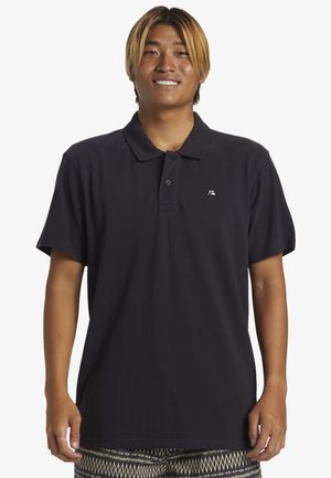Marine polo shirt lavet af blød bomuld med klassisk krave, to knaplukninger og et lille logo på venstre bryst. Korte ærmer, afslappet pasform.