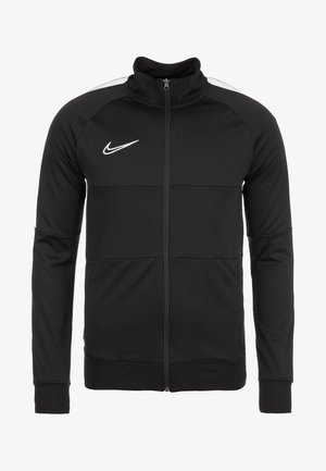 Veste de sport noire Nike zippée avec col haut, manches longues et logo Swoosh blanc sur la poitrine gauche.