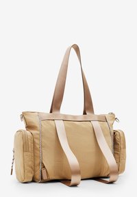 Beżowa torba nylonowa z płaskim dnem, dwoma górnymi uchwytami, bocznymi kieszeniami i skośnymi zamkami błyskawicznymi. Posiada teksturowaną powierzchnię materiału.