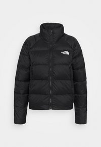 Giacca a vento nera con colletto alto, chiusura con zip, texture trapuntata e un piccolo logo bianco sul petto sinistro. Presenta polsini e orlo aderenti.