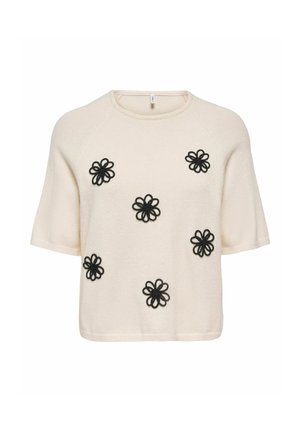 Pull crème à manches courtes avec six motifs floraux brodés noirs en boucle, espacés uniformément sur le devant.