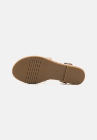 Brune sandaler med tekstureret fodseng, justerbar strop og gummisåler med riller for bedre greb. Størrelse 37, mærket "ANTI SLIDE."
