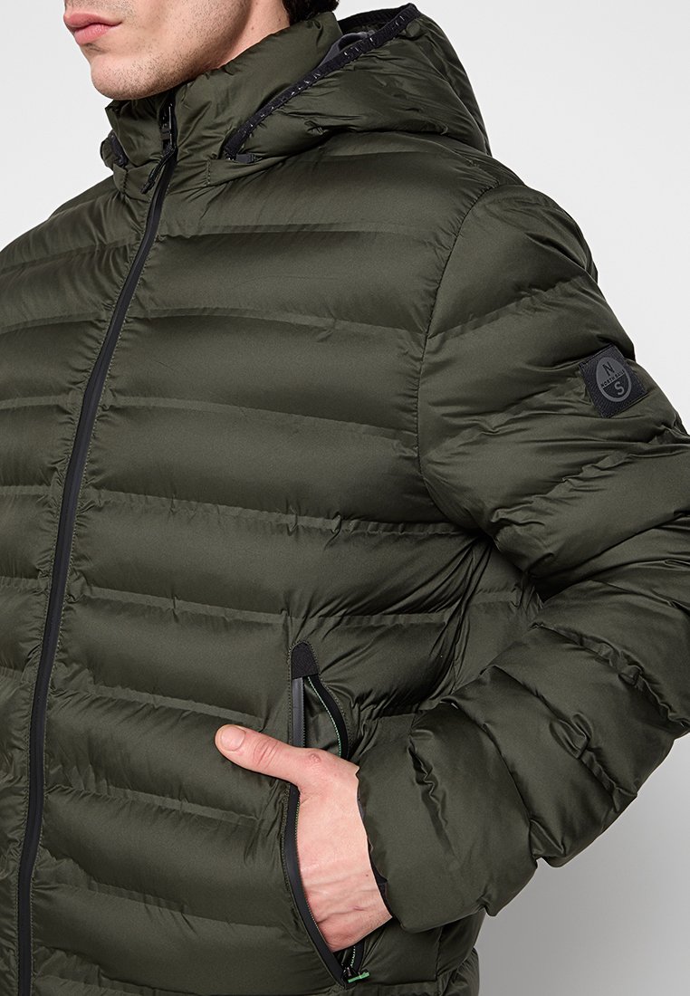 Giacca a vento verde oliva con cappuccio, caratterizzata da una texture trapuntata, chiusura zip frontale e tasche laterali. Dettaglio del logo sulla manica.