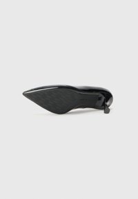 Scarpa con tacco alto in pelle lucidissima nera, con punta affilata, design elegante, suola texturizzata con motivo a pied-de-poule e hardware minimale.