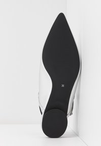 Chaussure blanche à talon haut avec bout pointu, dessus en cuir lisse, semelle noire et taille 36 inscrite en dessous.