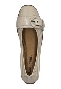 Zapato plano de cuero beige con una correa y hebilla de charol brillante, puntera redonda y plantilla acolchada. Nombre de la marca impreso en la suela.