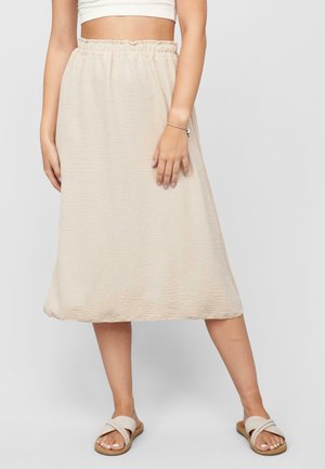 Lichtbeige midi-rok met een gekreukelde textuur, een elastische tailleband en een relaxte silhouet, gecombineerd met beige instappers.