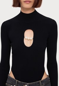 Schwarzer gerippter Body mit Rollkragen, ausgestattet mit einem ovalen Ausschnitt, der in der Mitte mit drei Perlen verziert ist. Figurschmeichelnder Schnitt mit langen Ärmeln.