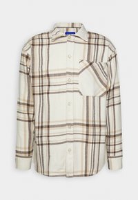 Camicia a quadri con quadrati beige e marroni, maniche lunghe, chiusura a bottoni e una tasca sul petto. Realizzata in tessuto morbido con design a colletto.
