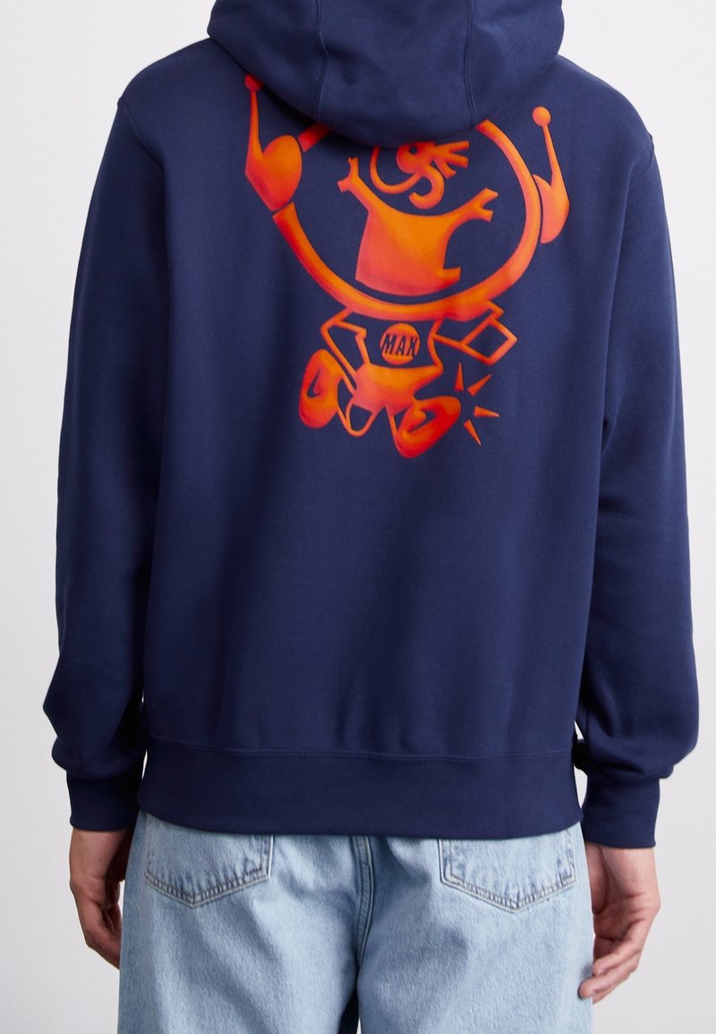 Mörkblå huvtröja med en livlig orange grafisk design av en karaktär på baksidan, med ribbade muddar och fåll.