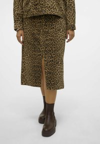 Leopardenmuster-Rock mit einem Vorder-Schlitz; aus strukturierter Stoff gefertigt. Kombiniert mit dunkelbraunen Plattform-Stiefeletten.