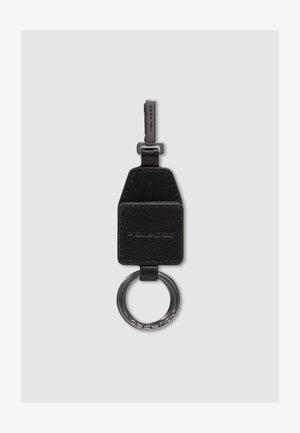 Porte-clés en cuir noir avec anneau et clip en métal, présentant un logo embossé sur les parties en cuir et en métal.