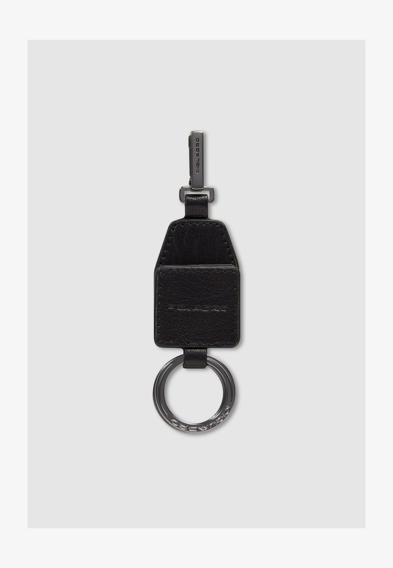 Porte-clés en cuir noir avec anneau et clip en métal, présentant un logo embossé sur les parties en cuir et en métal.