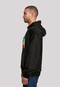 Schwarzer Kapuzenpullover mit einem bunten grafischen Design in Blau, Grün, Orange und Schwarz, mit einer Fronttasche und gerippten Bündchen.