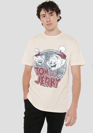 Cream-colored t-shirt features a graphic of Tom and Jerry. The design includes red and blue accents with a vintage, distressed look.