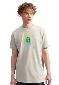 Lichtgrijs katoenen T-shirt met een levendige, abstracte print van een gezicht en vormen in blauw, groen en geel op de voorkant. Korte mouwen.