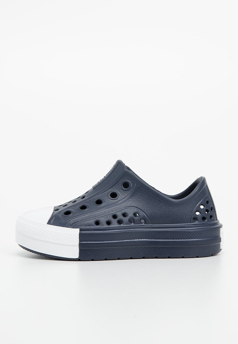 Marineblaue Schlupfschuhe aus Gummi, ausgestattet mit mehreren Belüftungslöchern, einer weißen Gummikappe und einer flachen Sohle.