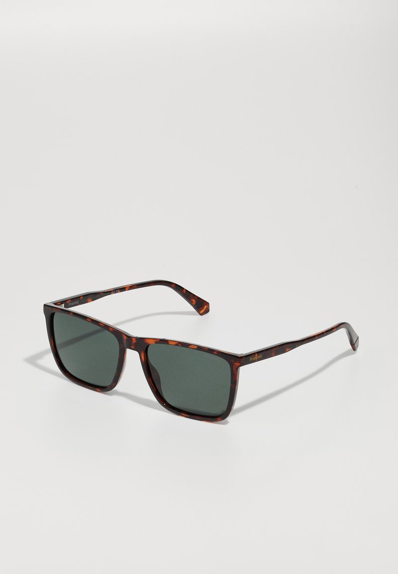 Ochelari de soare pătrați din material tortoise cu lentile polarizate verde închis. Prezintă brațe subțiri cu un branding subtil. Textură netedă din plastic.