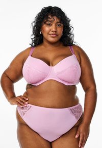 Light pink bra and matching panties with lace accents. The bra has molded cups, adjustable straps, and a smooth finish. Soft, stretchy material.