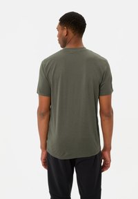 T-shirt à manches courtes vert olive avec un col rond ; tissu en coton doux ; coupe normale ; design uni sans logos ou motifs visibles.