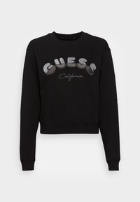 Černá zkrácená mikina vyrobená z bavlněné směsi. Obsahuje stříbrný třpytivý nápis "GUESS" a text "California". Dlouhé rukávy a žebrované manžety.