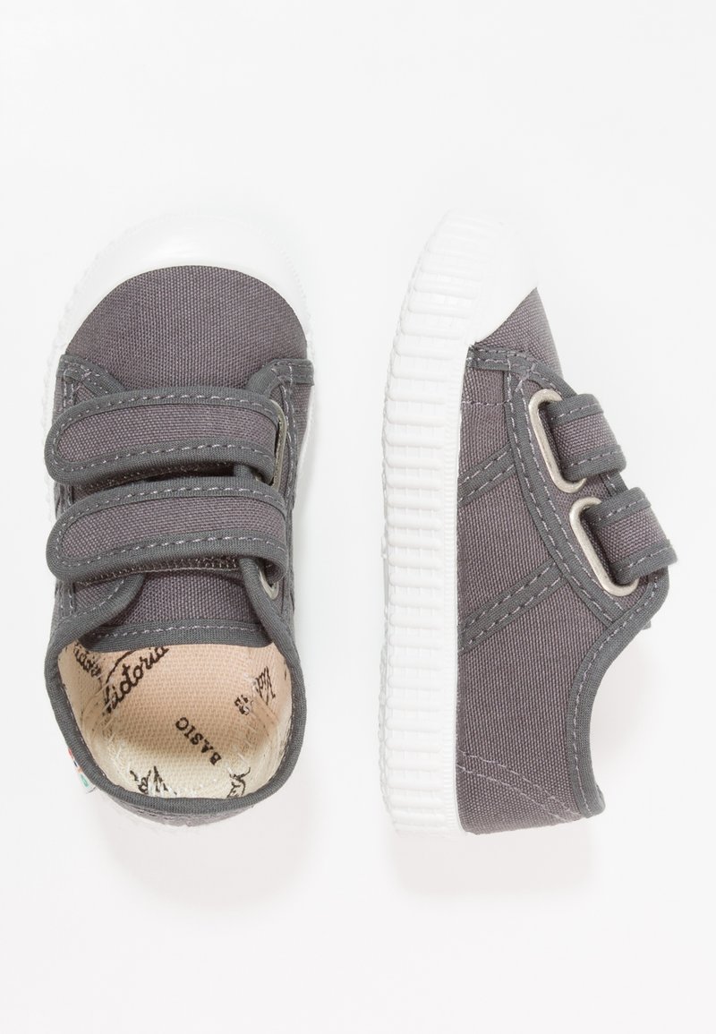 Sneakers in tela grigia con due cinturini in Velcro, suola in gomma bianca e dettagli di cucitura; interno morbido e testurizzato con etichetta del brand.