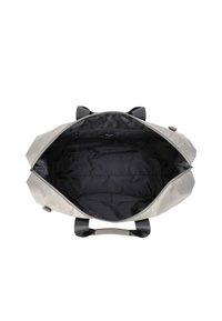 Šedá taška typu duffel s černým vnitřkem, jednou kapsou na zip, černými držadly a široce otevřeným vrškem ukazujícím prázdný vnitřek.