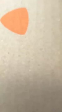 Orange triangular shape on a textured light brown surface, with subtle speckles and a matte finish. No additional details visible.