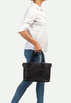 Zwarte leren handtas met dubbele handvatten, rechthoekige vorm en gestructureerd oppervlak. Beschikt over een ritssluiting en een hangtag.