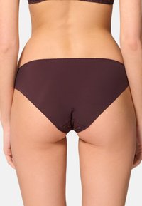 Burgundy damunderkläder med en mjuk tygkvalitet och spetsdetaljer längs kanterna, som erbjuder en åtsittande och minimalistisk design.