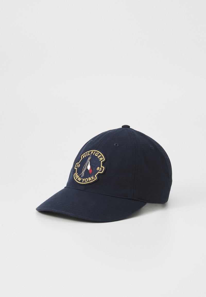 Marine baseballcap med et broderet logo-patch, justerbar rem bagpå og en buet skygge. Fremstillet af stof med en glat tekstur.