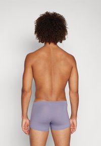 Lila Boxer-Briefs mit enganliegendem Schnitt, aus weichem Material gefertigt. Der Bund ist glatt, und das Design ist einfach ohne zusätzliche Muster.