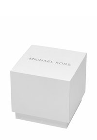 Biały kwadratowy pudełko o teksturowanej powierzchni, z nazwą marki "MICHAEL KORS" w kolorze srebrnym, umieszczoną wyraźnie na pokrywce.
