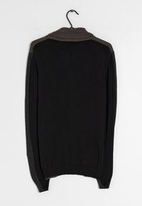 Suéter negro con cuello alto, con detalles grises en los hombros y puños acanalados. Tela suave con un diseño entallado y detalles mínimos.