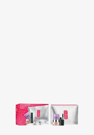 Trousse de maquillage argentée avec des accents roses, contenant des produits de soin de la peau : des pots de crème et un mascara. La boîte présente un design étoilé rose.