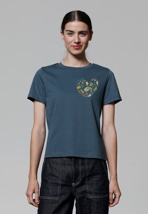 T-shirt bleu en coton, avec un graphique en forme de cœur de couleurs vives. Manches courtes et col rond, avec une coupe ample.