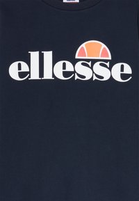 Felpa blu navy con un grande logo bianco "ellesse" e un design semicircolare arancione e rosso sopra il testo. Materiale in cotone, collo rotondo.