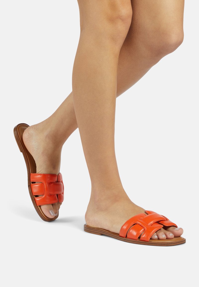 Sandales slides en cuir orange avec un design supérieur tissé, style ouvert aux orteils et semelle plate marron. Texture lisse et détails simples.