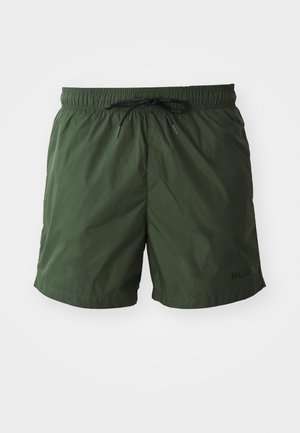 Shorts de bain verts en matériau léger, avec une taille élastique, un cordon noir et un petit logo noir sur le devant.