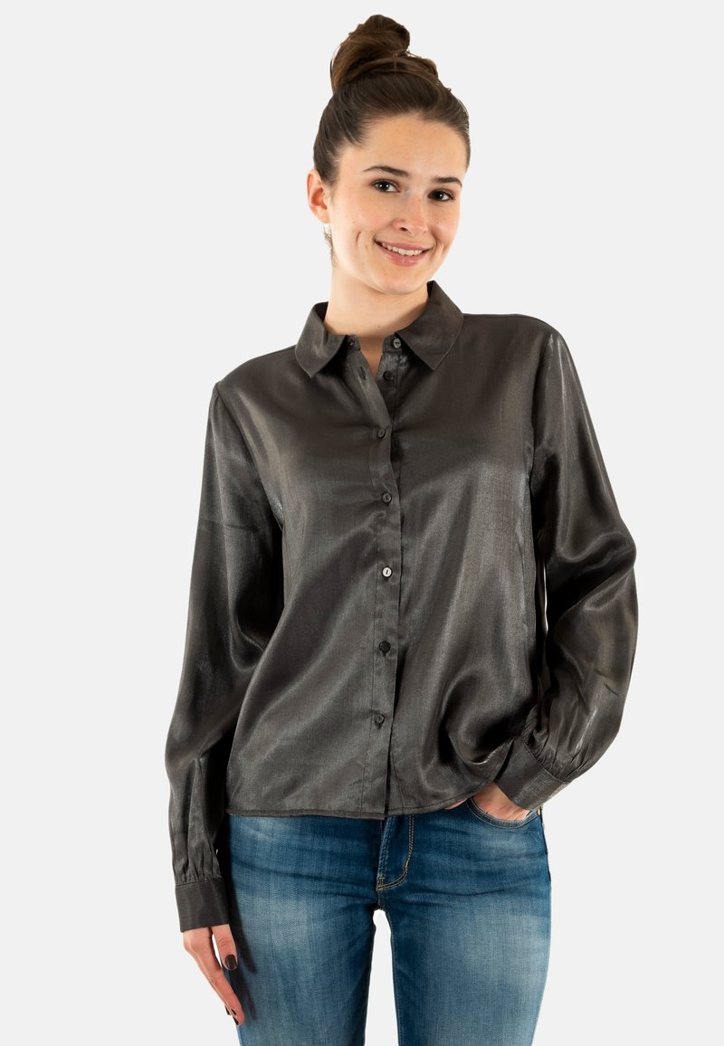 Camicia a maniche lunghe grigio scuro con tessuto liscio e lucido, chiusura davanti con bottoni e colletto a punta, abbinata a jeans blu.