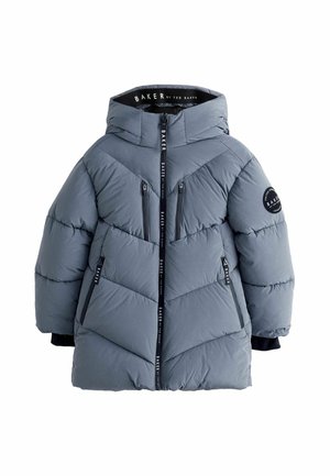 Dreng iført en lang, puffet grå vinterjakke med hætte og lynlåslommer på brystet, smilende og stående mod en ensfarvet baggrund.