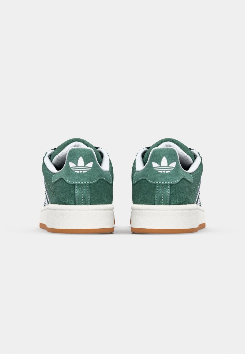 Grüne Wildleder-Sneaker mit weißen Akzenten, ausgestattet mit einem weichen, gepolsterten Kragen und einer Gummisohle. Adidas-Logo auf der Rückseite.