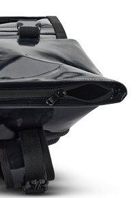 Fekete vízálló táska fényes felülettel, cipzáros nyitással, állítható pántokkal és a pántokon kidolgozott textúrával. Tartós és stílusos dizájn.