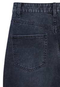 Jean en denim foncé avec une finition texturée, présentant une poche arrière unique, des passants de ceinture standard et un aspect légèrement décoloré.