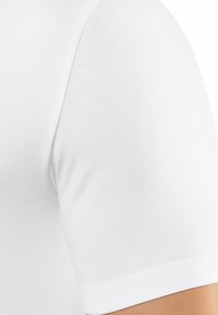 White cotton T-shirt featuring a fitted design, short sleeves, and a smooth texture with a plain finish and no visible patterns or accents.