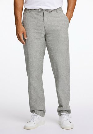 Pantalons en lin gris clair avec une coupe décontractée, taille à cordon, et poches latérales, associés à des baskets blanches. Texture lisse, design décontracté.