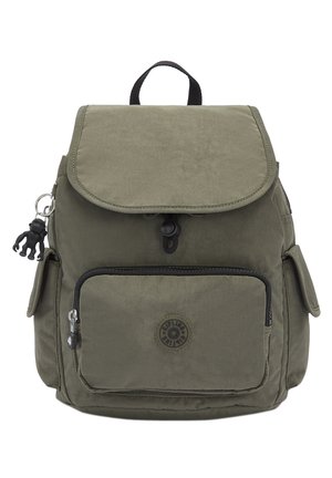 Zaino khaki con chiusura a patta, tasca frontale con zip e tasche laterali. Presenta una toppa con logo e un accessorio portachiavi. Realizzato in tessuto resistente.